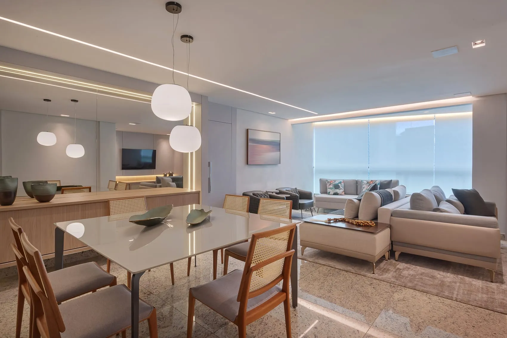Sala de jantar e estar integradas, com pendentes esféricos e vista pela janela