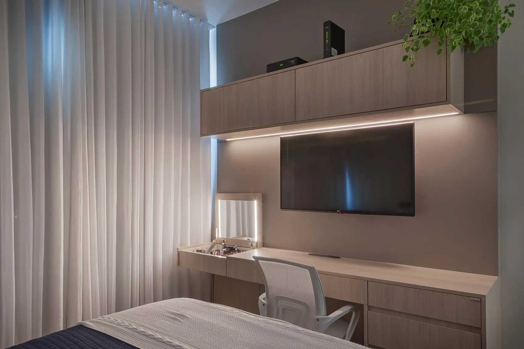 Quarto com bancada de trabalho embutida, painel de TV e prateleira suspensa