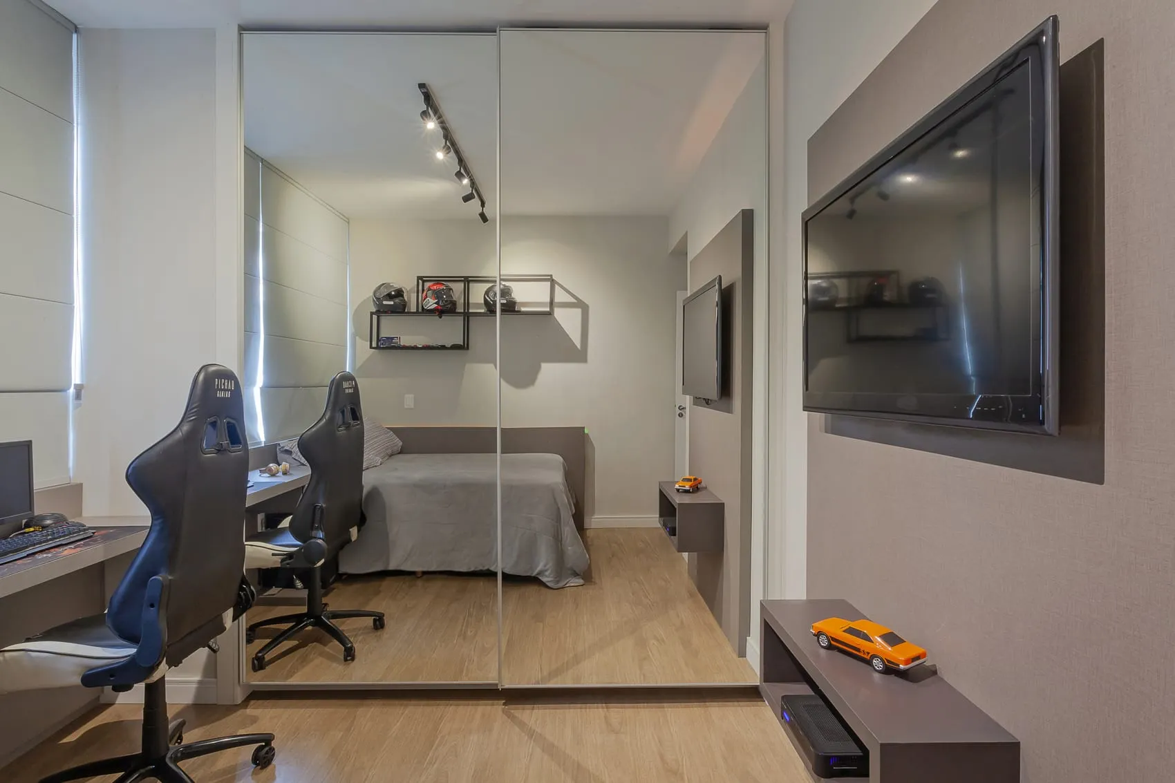 Quarto com setup de jogos, cadeiras gamer, painel de TV e armário espelhado