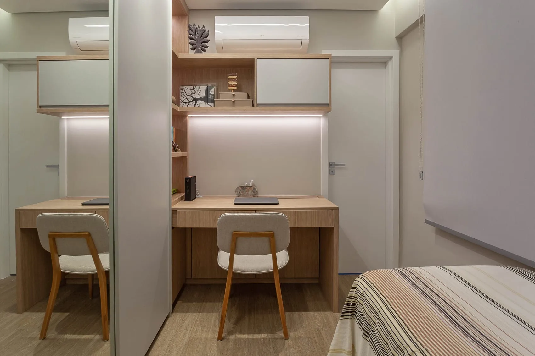 Bancada de trabalho embutida no quarto, com prateleiras e cadeiras claras