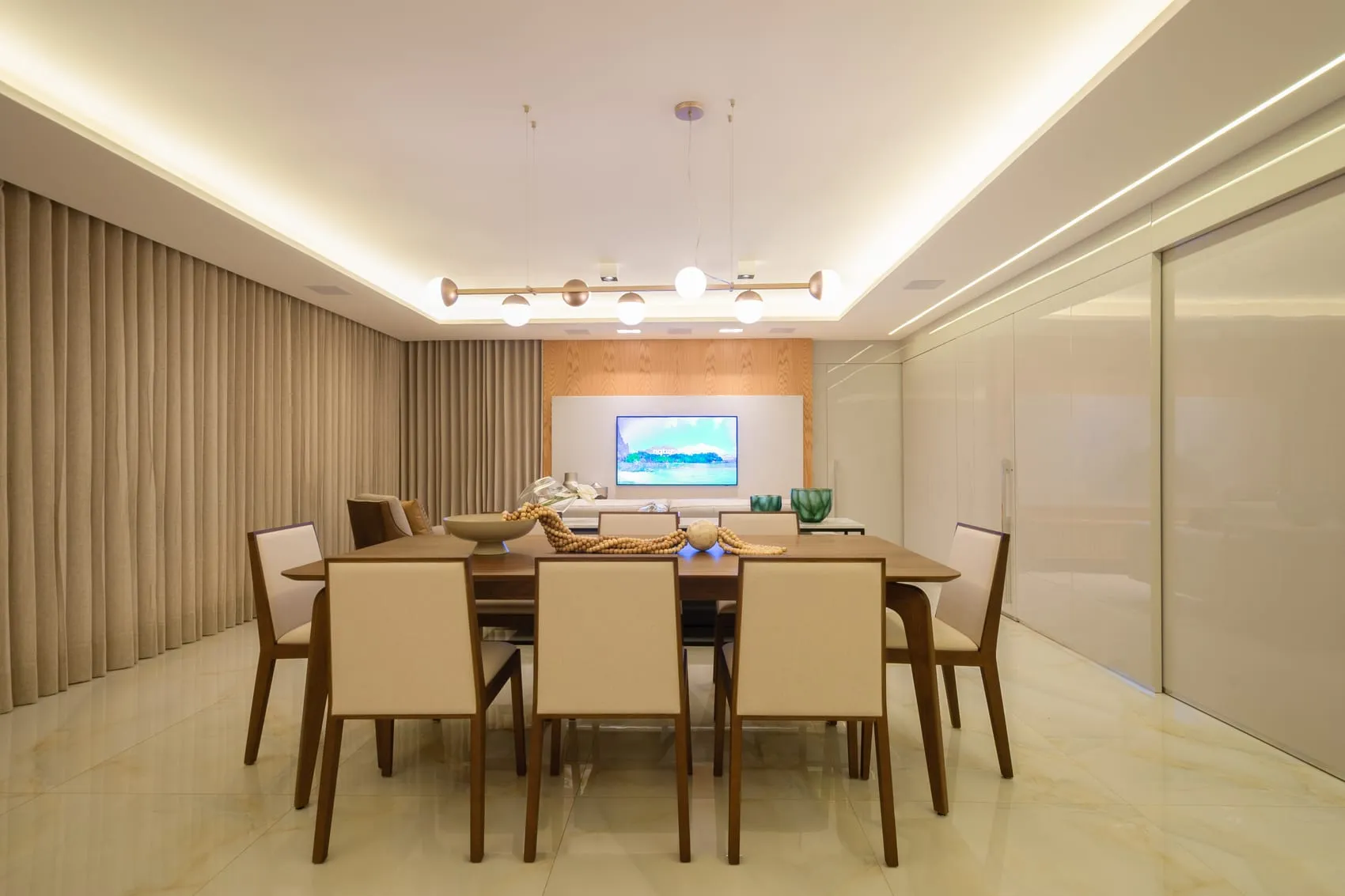 Sala de jantar com luminária linear, painel ripado e portas de vidro