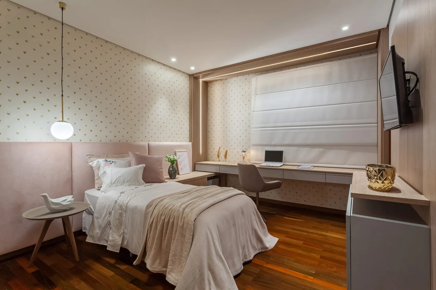 Quarto com papel de parede discreto, bancada de trabalho e televisão