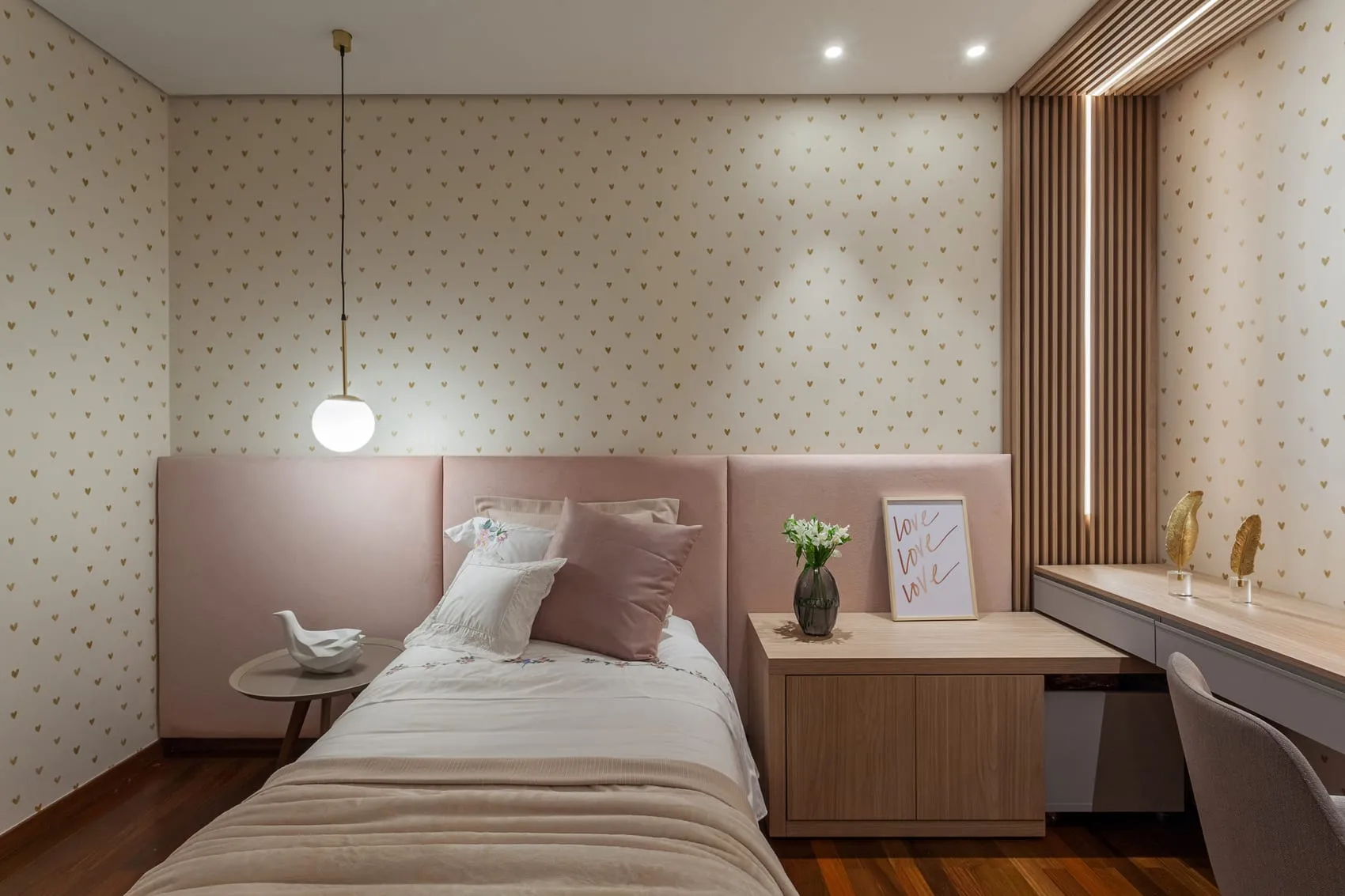 Quarto em tons de rosa com penteadeira e pendente de vidro