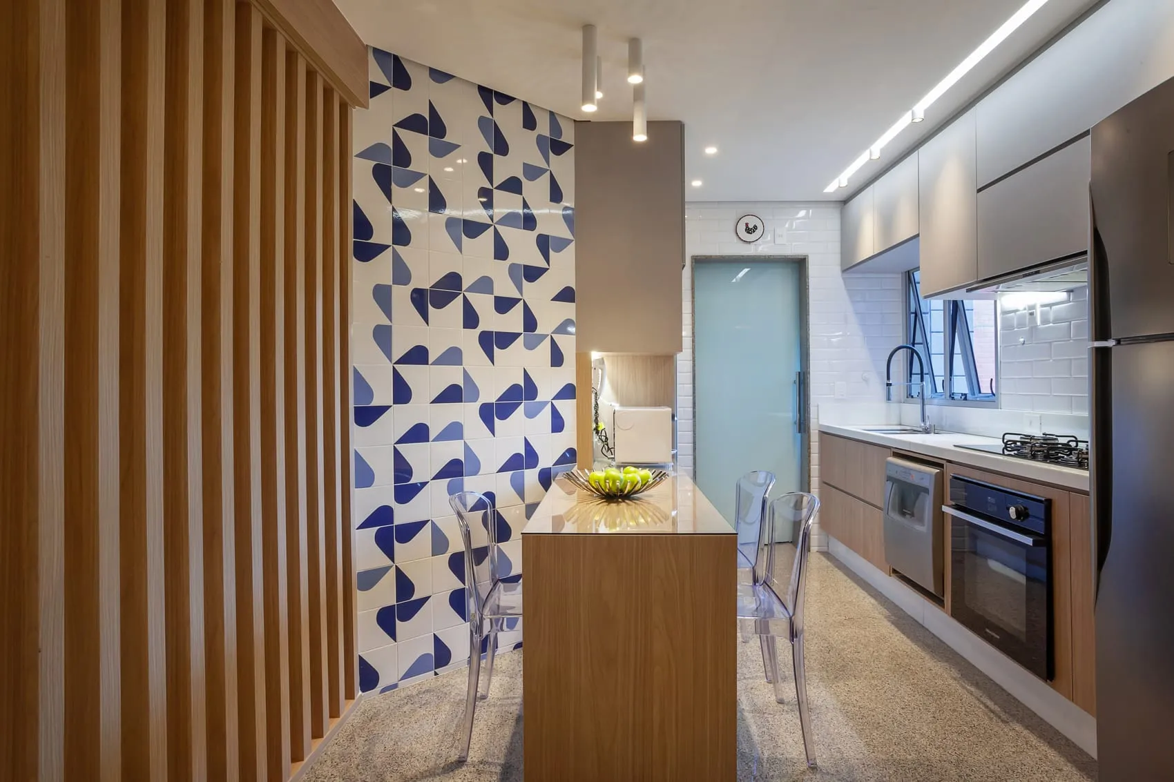 Cozinha com ilha central, ripado de madeira e papel de parede azul