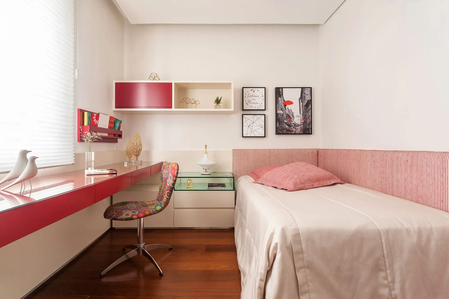Quarto de solteiro com bancada de estudos em laca vermelha, nichos e cabeceira rosa