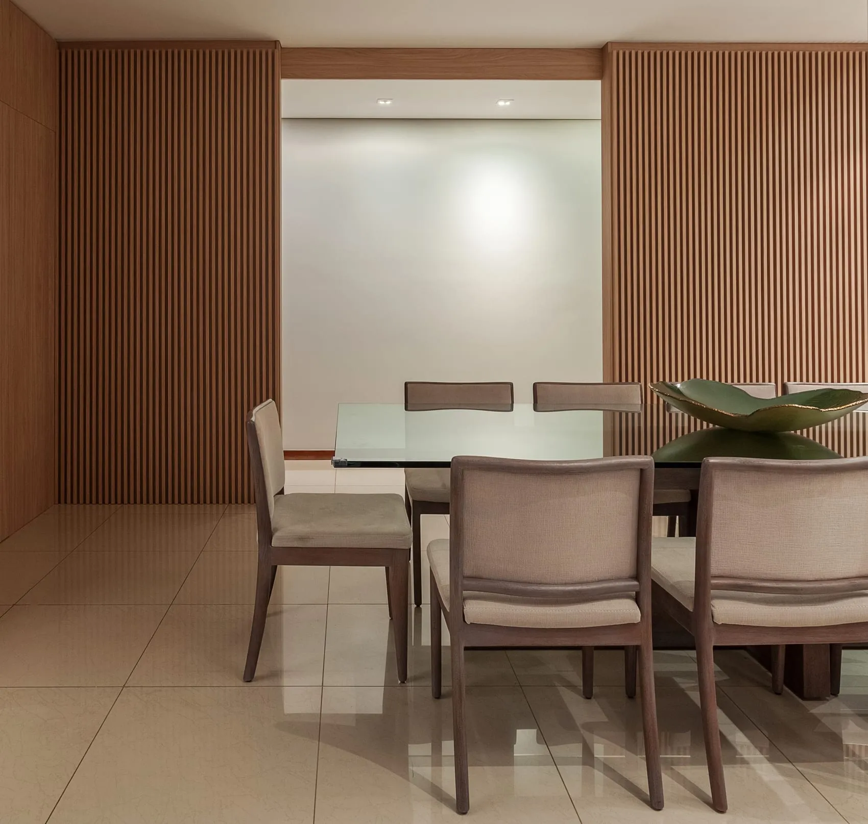 Sala de jantar em outro ângulo, com marcenaria ripada e iluminação embutida