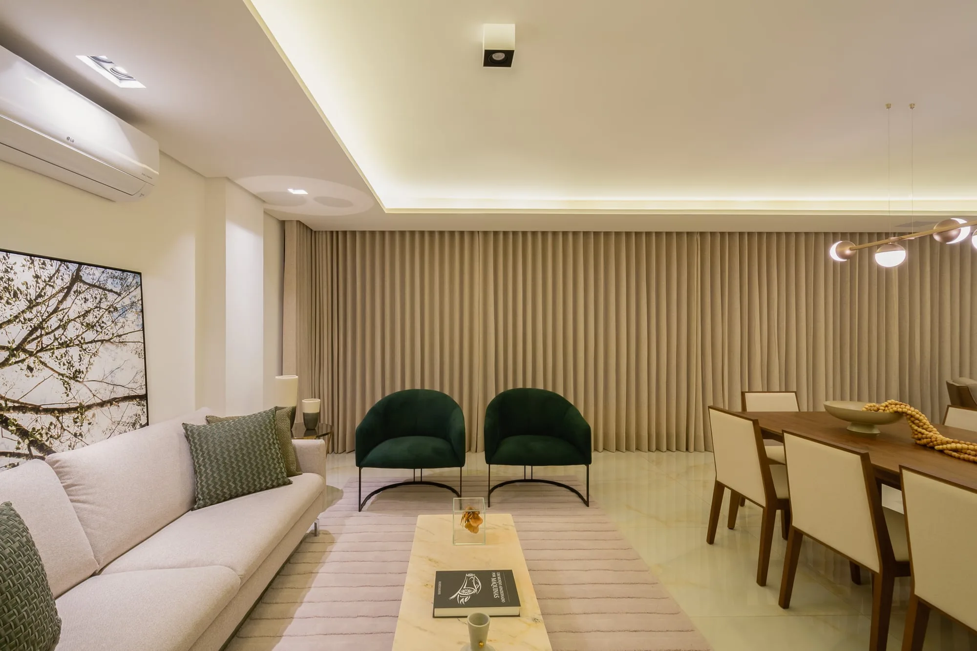 Sala de estar com sofá claro, poltronas verdes e painel ripado em madeira